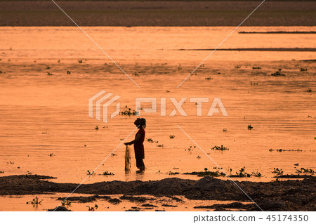 Asian Woman fishing in the river at sunset Asian Woman fishing in the river at sunset 45174350