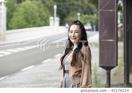 In front of a woman bus stop Museum International Center 45176214