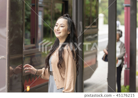 In front of a woman bus stop Museum International Center 45176215