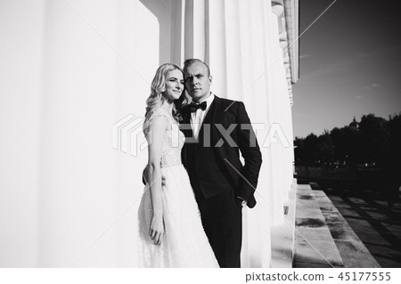 Man and woman in wedding clother stand near the big pillar Man and woman in wedding clother stand near the big pillar 45177555