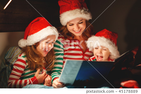 Merry Christmas! family mother reads to children book before bed Merry Christmas! family mother reads to children book before bed 45178889