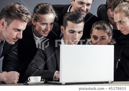 Business team look together at laptop Business team look together at laptop 45178933