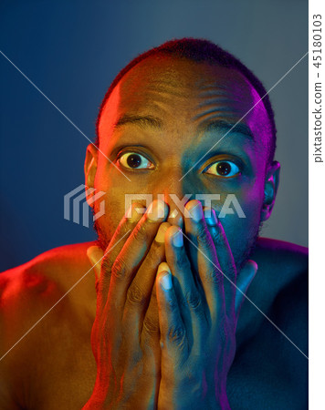 Close up portrait of a young naked african man looking at camera indoors Close up portrait of a young naked african man looking at camera indoors 45180103