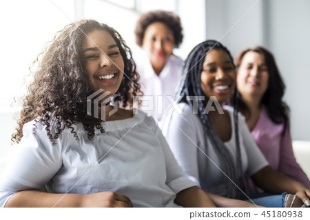 Two family Friends Sitting On Sofa Together Two family Friends Sitting On Sofa Together 45180938