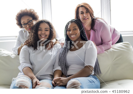Two family Friends Sitting On Sofa Together Two family Friends Sitting On Sofa Together 45180962