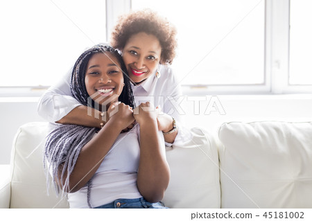 affectionate mother and daughter sitting on sofa affectionate mother and daughter sitting on sofa 45181002