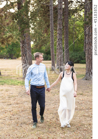 Man and woman mixed race walking and holding hands Man and woman mixed race walking and holding hands 45183852