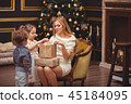 Mom and her children near the Christmas tree 45184095