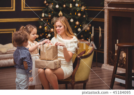 Mom and her children near the Christmas tree 45184095