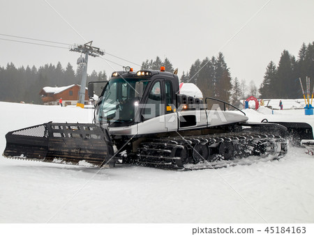 A black snowcat in action 45184163