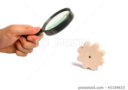 Magnifying glass is looking at the Wooden gear Magnifying glass is looking at the Wooden gear 45184633