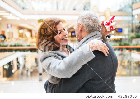 Senior couple with present doing Christmas shopping. Senior couple with present doing Christmas shopping. 45185019