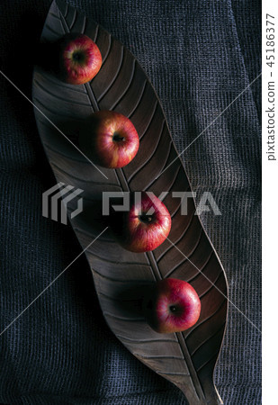 Red apples on a wooden tray in low light Red apples on a wooden tray in low light 45186377