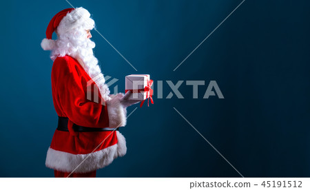 Santa holding a Christmas gift 45191512