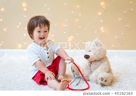 Toddler boy with teddy bear doctor 45192163