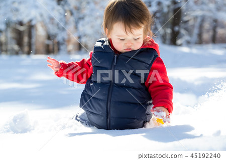 Toddler boy playing in the snow Toddler boy playing in the snow 45192240