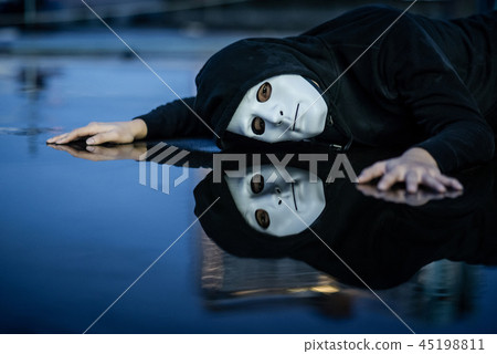 Mystery man in white mask lying on wet floor Mystery man in white mask lying on wet floor 45198811