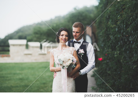 Happy wedding couple walking in a botanical park 45200265