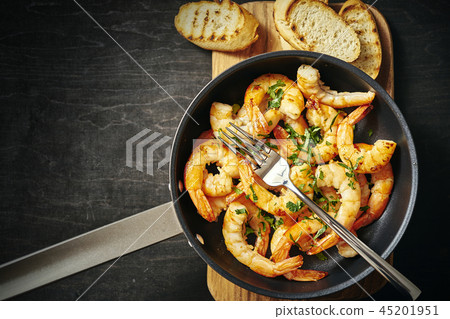 fresh delicious fried prawns in a pan and toasts on wooden board fresh delicious fried prawns in a pan and toasts on wooden board 45201951