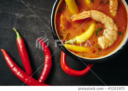 traditional Thai soup with shrimp in a red pot and chilli pepper traditional Thai soup with shrimp in a red pot and chilli pepper 45201955
