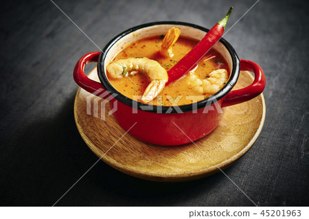 traditional Thai soup with shrimp in a red pot with chilli pepper traditional Thai soup with shrimp in a red pot with chilli pepper 45201963