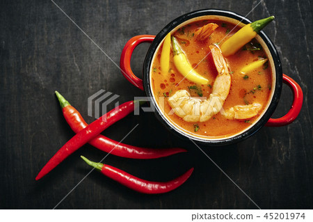 traditional Thai soup with shrimp in a red pot and chilli pepper traditional Thai soup with shrimp in a red pot and chilli pepper 45201974