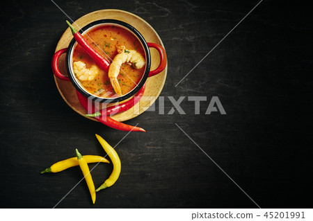 traditional Thai soup with shrimp in a red pot with chilli pepper traditional Thai soup with shrimp in a red pot with chilli pepper 45201991
