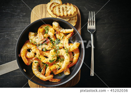 fresh delicious fried prawns in a pan and toasts on wooden board fresh delicious fried prawns in a pan and toasts on wooden board 45202036