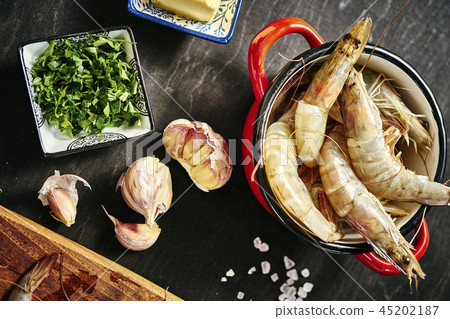 fresh delicious raw tiger prawns in a pot with parsley, lemon, butter and garlic fresh delicious raw tiger prawns in a pot with parsley, lemon, butter and garlic 45202187