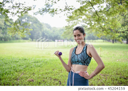 Exercise concept. Beautiful girl is stretching her muscles. Beau Exercise concept. Beautiful girl is stretching her muscles. Beau 45204159