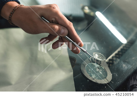 Close up Automobile glazier worker fixing and repair windscreen or windshield of a car in auto 45210054