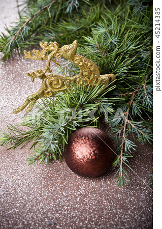 Evergreen fir tree branch, golden deer brown ball. 45214385
