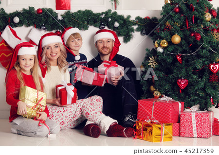 Cheerful family with Christmas gifts Cheerful family with Christmas gifts 45217359