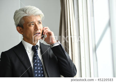 Middle-aged businessman romance gray making phone calls at the windowsill Middle-aged businessman romance gray making phone calls at the windowsill 45220583