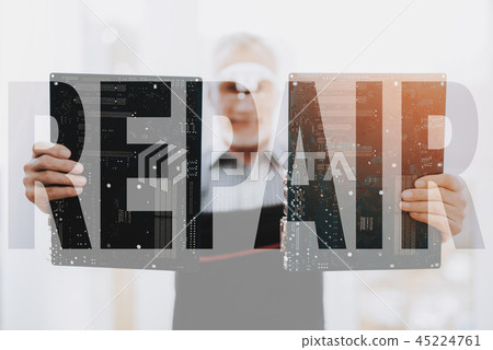 Hands of Senior Repairman Holding Motherboards. 45224761
