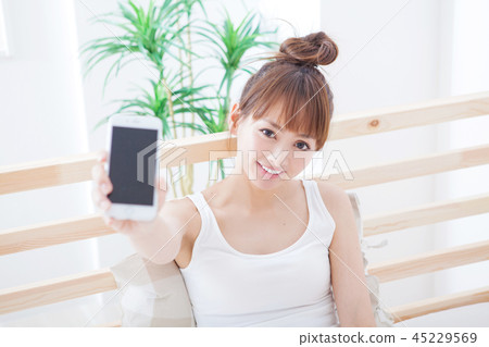 Woman showing the screen of the smartphone 45229569
