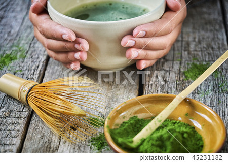 Girl's hands holding matcha tea in special matcha tea bowl with bamboo spoon and whisk Girl's hands holding matcha tea in special matcha tea bowl with bamboo spoon and whisk 45231182