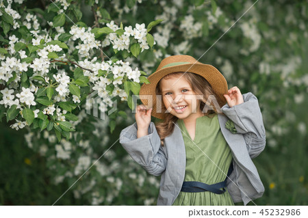 Happy girl in a beautiful dress cherry blossoms Happy girl in a beautiful dress cherry blossoms 45232986