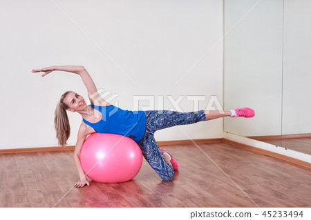Athletic woman makes exercises on a fitness ball , indoors gym. 45233494