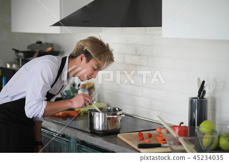 Asian cook in the kitchen prepares food in a cook suit 45234035