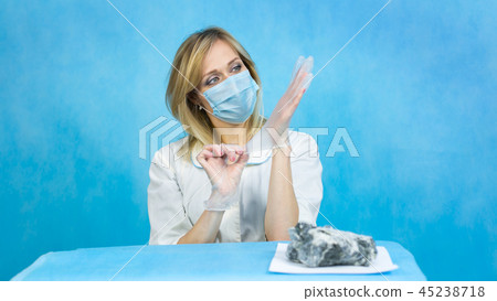 Girl lab technician puts gloves on his hands. Girl lab technician puts gloves on his hands. 45238718