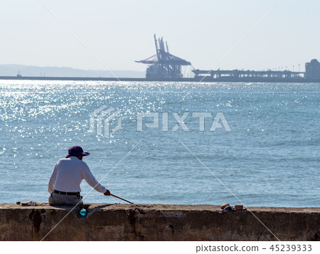 The fisherman fishes at the beach The fisherman fishes at the beach 45239333