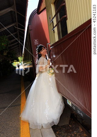 Vertical photo of bride trying to get on sightseeing train at Kuranda station yard 45241183