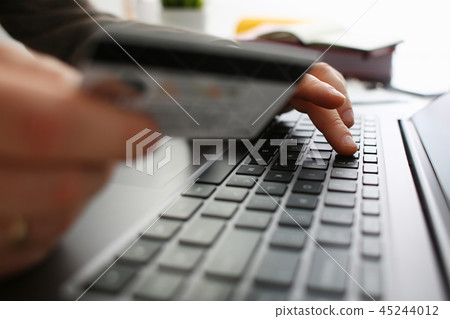 Male arms hold credit card press buttons making transfer 45244012