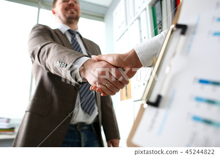Man in suit and tie give hand as hello in office 45244822