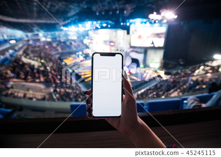 Woman's hands using digital application on the mobile smart phone at esport event at big arena. Copy Woman's hands using digital application on the mobile smart phone at esport event at big arena. Copy 45245115