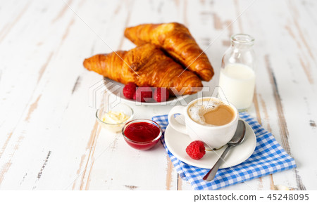Cup of coffee and two croissants for breakfast on white table 45248095