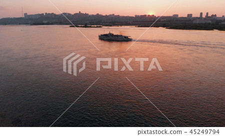 Aerial view of the ship sailing on the river in the city at sunset. 45249794