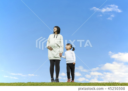 握在藍天背景和注視距離的小女孩和母親手。親子,家庭,愛情,幸福形象 握在藍天背景和注視距離的小女孩和母親手。親子,家庭,愛情,幸福形象 45250308