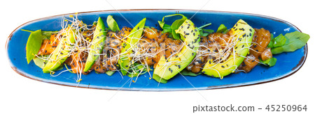 Delicious salmon tartare garnish with avocado on blue plate 45250964